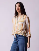 Blusa estampada de Zac & Rachel con cuello a la base, escote en V y botones. Tiene un bolsillo aplicado en la parte delantera, mangas largas regulables con presilla y botón, y terminación anudada opcional.
