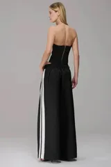 Corset strapless negro con paneles laterales en color blanco, diseño estructurado con costuras visibles y corte asimétrico en la cintura.