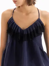 Top de tirantes azul marino con volados fruncidos en el escote adornados con encaje negro.