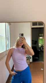 Top sin mangas de cuello redondo, confeccionado en tela texturizada y elastizada, con ajuste al cuerpo.