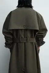 Trench de corte relajado confeccionado en tejido compacto de algodón. Presenta cuello solapa en color contraste, cierre frontal con botonadura oculta, bolsillos de vivo en la cadera y cintura ajustable con cinturón del mismo tejido. Las mangas largas cuentan con puños con trabilla y el bajo es ajustable en el centro de la espalda.