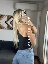 Top asimétrico negro con un solo tirante y detalle de strass plateados.