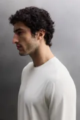 Camiseta de entrenamiento de manga larga y cuello redondo, confeccionada en tejido técnico ligero y elástico con tecnología de secado rápido. Presenta costuras planas para mayor resistencia y comodidad durante el movimiento, con un pequeño logo estampado en el bajo.