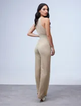 Enterito largo de gasa lurex plisada color dorado, con escote halter, cintura elastizada con punto smock, abertura en la espalda con cierre invisible y forro interno a tono.