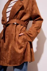Trench marrón de gamuza vegana con cuello solapa, manga larga, cinturón con hebilla y corte evasé.