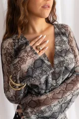Vestido corto confeccionado en tul y lycra con estampado animal print de serpiente, escote en V pronunciado y mangas largas con diseño acampanado.