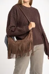 Sweater de lana y nylon color marrón oscuro, con diseño de punto trenzado (cable knit) y cuello redondo. Presenta un calce oversize.