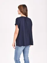 Blusa azul marino de corte holgado, con cuello en V y mangas cortas.