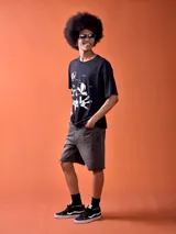 Remera negra con diseño estampado de Mickey Mouse en color blanco con estilo de dibujo animado clásico y texto "Oh Boy".