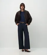 Pantalón de sastrería corte recto, color marrón, con cintura de tiro medio, trabillas largas y bolsillos traseros.