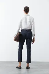 Pantalón de vestir negro de corte recto, con cintura estructurada y costura central vertical en las piernas que aporta un acabado sastrero.