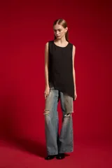 Musculosa de poliéster color nude, con cuello redondo y diseño asimétrico sin mangas.