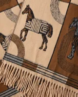 Poncho abierto en tonos marrón, beige y tostado, con diseño estampado de caballos y flecos en el ruedo.
