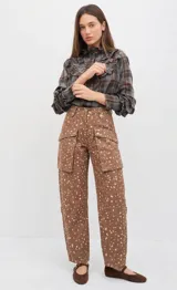 Jean de tiro alto con diseño cargo, color rosado con estampado de pequeñas manchas blancas. Presenta maxi bolsillos delanteros con botones a presión, bolsillos traseros con cierre metálico y corte recto de largo tobillero.