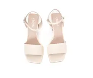 Sandalias de cuero color beige claro, con taco bloque medio y tiras cruzadas en la parte delantera y en el tobillo con hebilla ajustable.