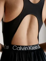 Vestido negro de punto acanalado elástico en la parte superior con escote cuadrado y espalda de nadador. La falda es de crepé tejido con vuelo y la cintura elástica lleva el logo repetido de Calvin Klein Jeans.
