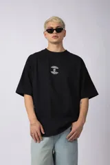 Remera negra de corte oversize con cuello redondo y mangas cortas. Presenta un pequeño estampado gráfico en color blanco en el centro del pecho.