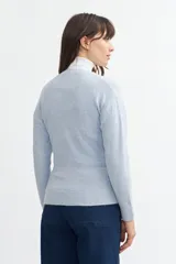 Sweater de tejido de punto color beige, con escote en V profundo, mangas largas y fit holgado.