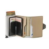 Billetera tarjetero automática con estructura de aluminio y revestimiento de cuero bicolor en tonos verde oliva y beige. Cuenta con un cierre de broche a presión y el logo de la marca grabado en la parte inferior.