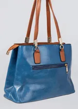Cartera azul de cuero sintético con doble asa corta color marrón. Tiene dos compartimentos principales con cierre y bolsillos internos. Incluye correa larga extraíble.