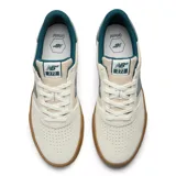 Championes New Balance Numeric 272, diseñados para skate, con capellada de gamuza y materiales sintéticos en tono crema, detalles en verde azulado y suela de goma color caramelo.