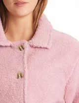 Sobrecamisa de tejido sherpa color blanco, con cuello solapa, cierre frontal con botones y bolsillos delanteros.