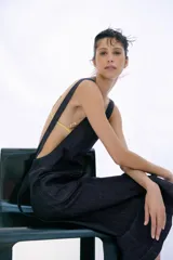 Vestido midi de denim color azul oscuro, confeccionado con mezcla de algodón. Presenta escote cuadrado, tirantes anchos, bolsillos delanteros de parche y falda de corte evasé.