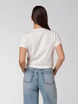 Remera blanca de corte crop con cuello redondo, mangas cortas y logo de Caterpillar estampado en negro en el frente.