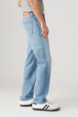 Jean de corte regular con tiro medio, confeccionado en denim de algodón con un toque de elastano para mayor comodidad. Presenta un lavado celeste clásico, cierre de botones y remaches metálicos.