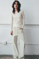 Jersey de punto fino con diseño color block en tonos rojo, bordó y blanco. Presenta cuello redondo y manga larga.