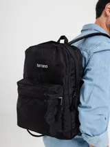 Mochila negra de estilo clásico con compartimento principal amplio, bolsillo frontal con cierre y bolsillos laterales. Incluye división interna para notebook.