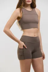 Minishort deportivo de tiro alto con bolsillos laterales, confeccionado en tejido elastizado de compresión media.