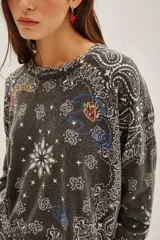 Sweater de punto en color gris oscuro con un diseño integral de estampado tipo bandana en color blanco y detalles gráficos coloridos. Posee cuello redondo, mangas largas y terminaciones acanaladas en puños y cintura.