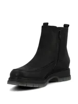 Botín tipo Chelsea de cuero negro con laterales elásticos, diseño de caña media y suela robusta de poliuretano con base gris traslúcida.