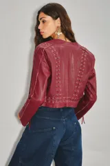 Saco corto de cuero ovino color bordó, con diseño de cordones entrelazados en el frente y los costados, manga larga y cuello mao.