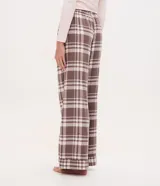 Pantalón de pijama de franela con estampado de cuadros en tonos marrón y blanco. Presenta un corte holgado, cintura elástica y diseño cómodo ideal para el descanso.