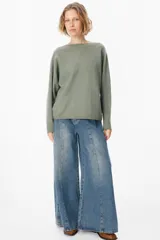 Sweater de silueta holgada con cuello a la base, mangas murciélago y ruedo redondeado. Confeccionado en tejido de punto fino monocolor.