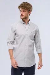 Camisa celeste a rayas verticales, de manga larga con opción de enrollar, corte slim fit, con bolsillo en el pecho y confeccionada en algodón.