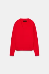 Jersey de punto color rojo, con escote en pico y manga larga. Los puños y el bajo tienen acabados en rib.