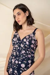 Vestido largo de tul azul con bordado de flores en tonos ocre y rosa pálido. Tiene breteles finos, corte al cuerpo y falda con godets y ruedo armado.