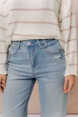 Pantalón de jean tiro alto con calce wide leg, color celeste claro con lavado suave y detalle de desgaste en el bolsillo delantero.