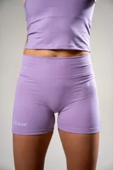Calza deportiva corta color lila con tiro alto y logo de la marca en el muslo.