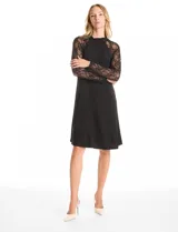 Vestido midi negro con cuello alto y mangas largas de encaje. Presenta una abertura en la espalda.