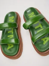 Sandalias de cuero vacuno color marrón con acabado brillante, diseño de dos tiras anchas acolchadas y plataforma baja.