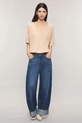 Remera oversize color blanco, confeccionada en jersey Pima flamé de algodón. Cuenta con escote en V, mangas cortas con detalle de bordado en la manga y cintura con elástico que genera un efecto balloon.