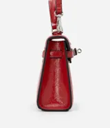 Cartera pequeña de poliuretano color rojo, con diseño estructurado, asa superior rígida y cierre frontal con herraje metálico.