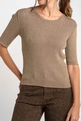 Sweater de punto acanalado color beige con hilos metalizados, de manga corta y escote redondo, corte ajustado al cuerpo.