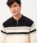 Suéter de punto Marfinno, color blanco y negro con diseño de rayas horizontales bicolor. Cuenta con cuello polo, cierre frontal completo y bolsillos laterales.