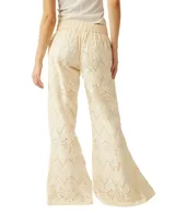 Pantalón de broderie color blanco, de pierna ancha, con cordón ajustable en la cintura y diseño calado con patrones geométricos.