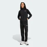 Conjunto deportivo Adidas compuesto por campera con cierre frontal y pantalón de corte clásico. Ambas prendas son de color negro, confeccionadas en tejido tricot, con bolsillos laterales y el logo de la marca estampado en blanco.